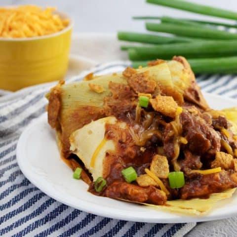 tamales with chili con carne on white plate