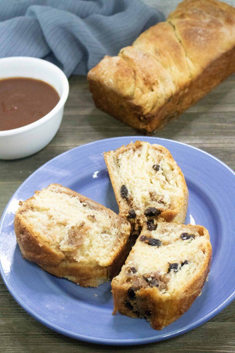 3 slices of Apple Butter Coffee Cake on a blue plate in front of a full loaf and small white bowl of apply butter