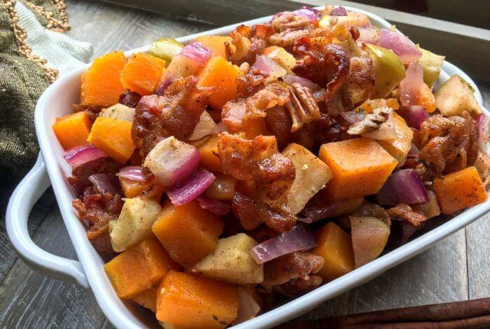 Apple Butternut Squash Casserole with Bacon Pecan Topping ready to serve in a white dish