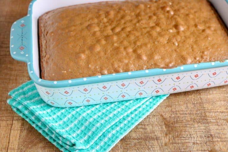 Baked spice cake in a 9x13 pan, cooling before it is poked
