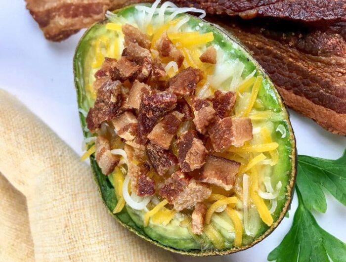 overhead view of baked avocado loaded with cheese and bacon bites
