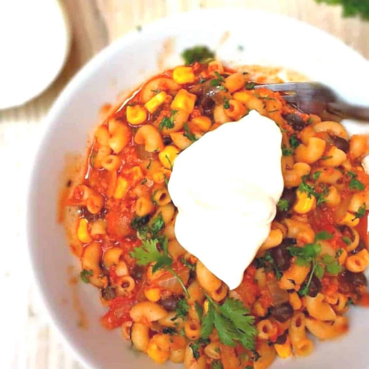 Overhead view of one-pot southwest chili mac topped with sour cream and cilantro