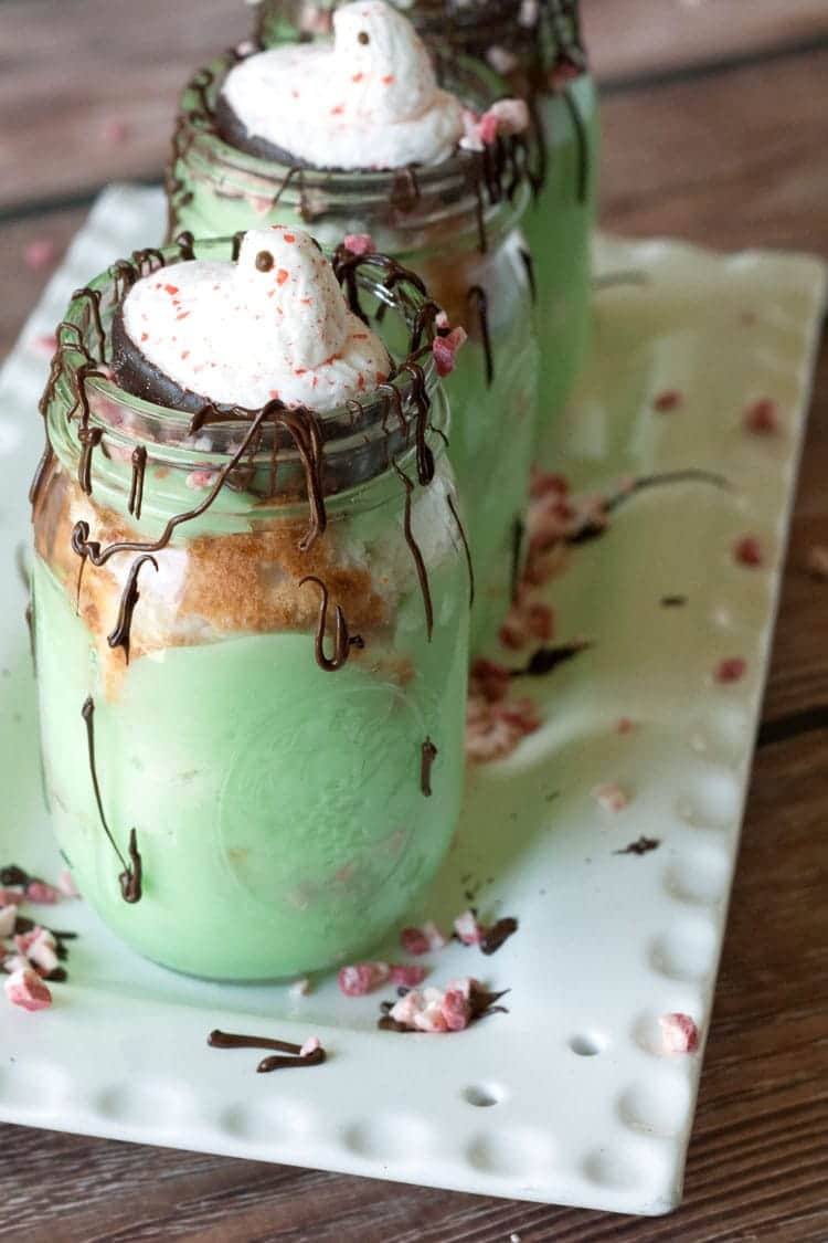 Christmas pistachio trifles with layers of pudding, cake and peppermint in mason jars