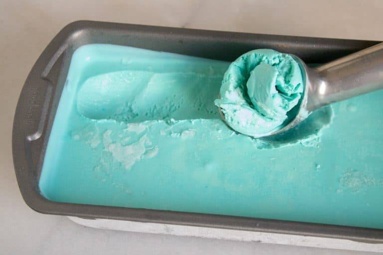 No-Churn Blue Moon Ice Cream frozen and being scooped by an ice cream scoop.