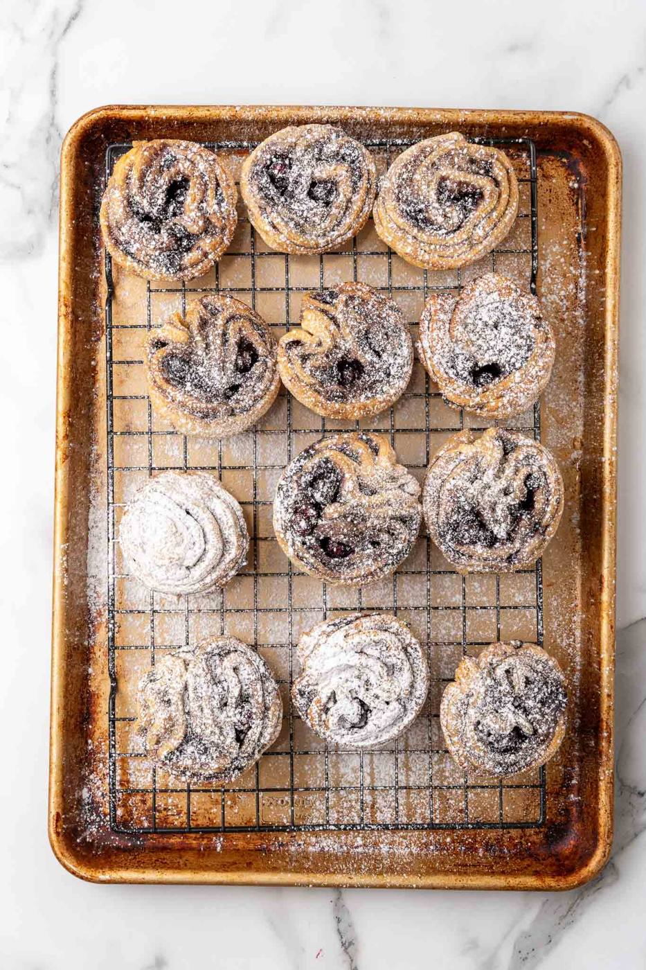 dusting Blueberry Cruffins with powdered sugar