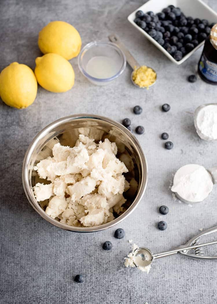 Store bought sugar cookie dough broken into pieces in mixing bowl.