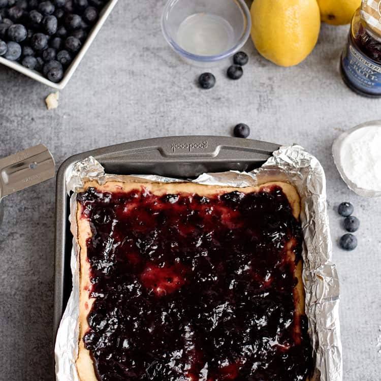 Baked sugar cookie dough with blueberry spread on top.