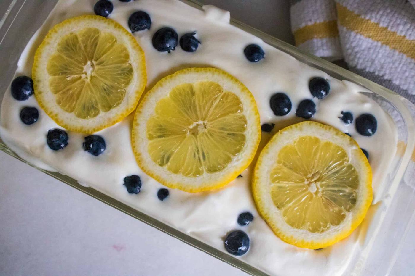 finished blueberry lemon no churn homemade ice cream in glass dish with lemon slices on top
