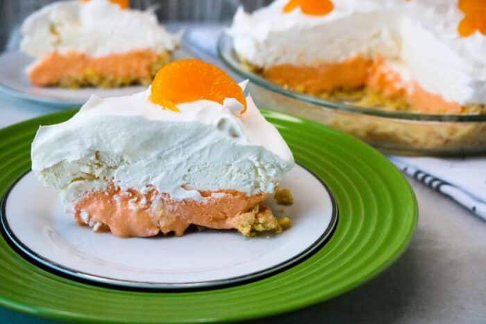 A slice of Boozy Orange Creamsicle Pie served on a green and white plate