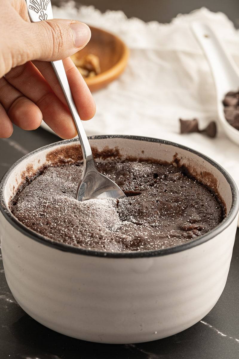 taking a spoonful of brownie mug cake
