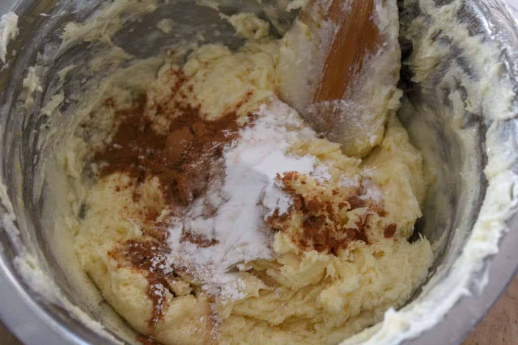 Dry carrot cake cookies ingredients added to the wet ingredients in the bowl