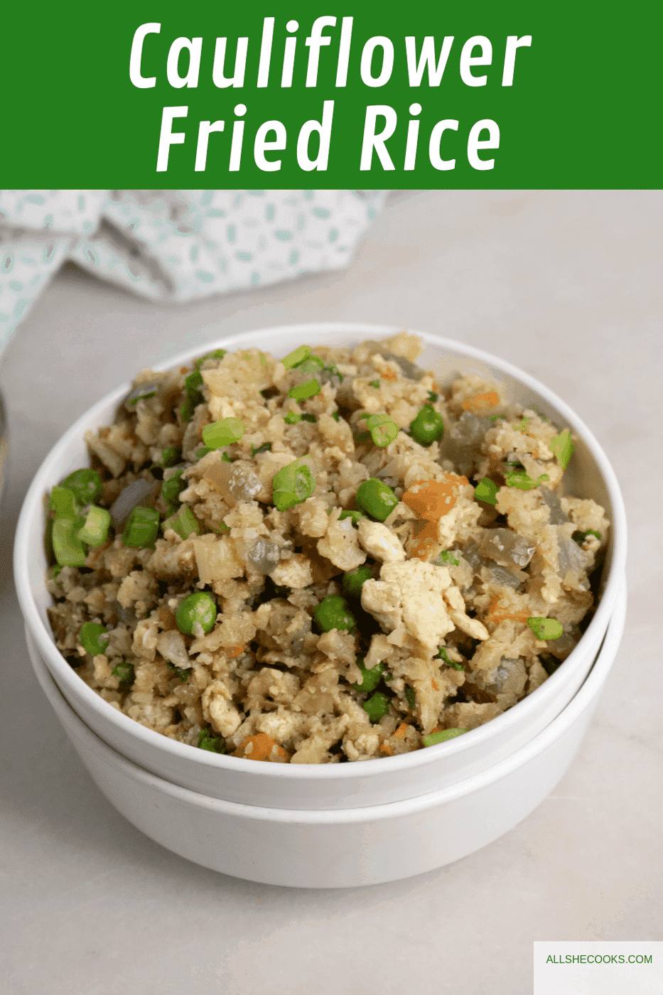 Cauliflower Fried Rice in a white bowl next to a blue print cloth napkin