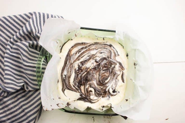 cheesecake brownies in a baking pan about to go into the oven