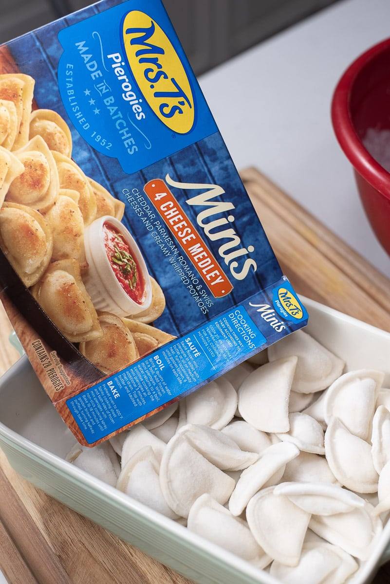 pouring pierogies into a baking dish