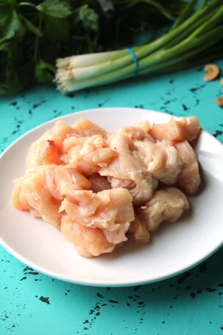 Cubed raw chicken breast on a white plate