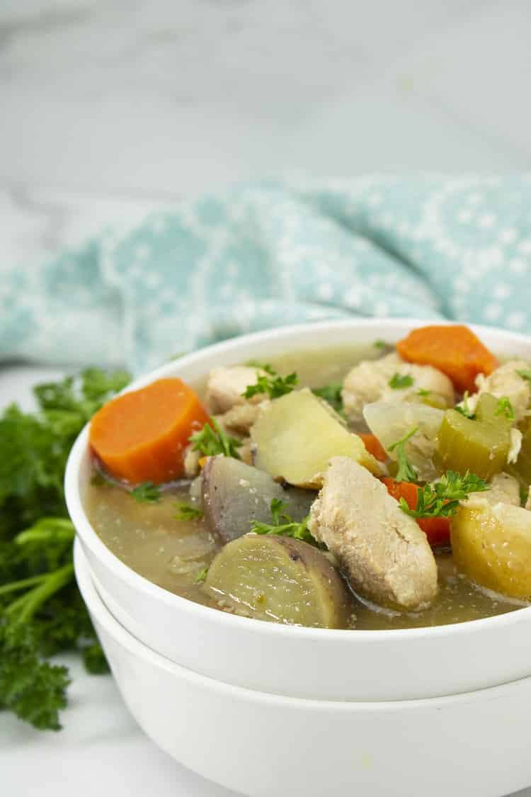 Slow cooker chicken stew with carrots and potatoes in a white bowl