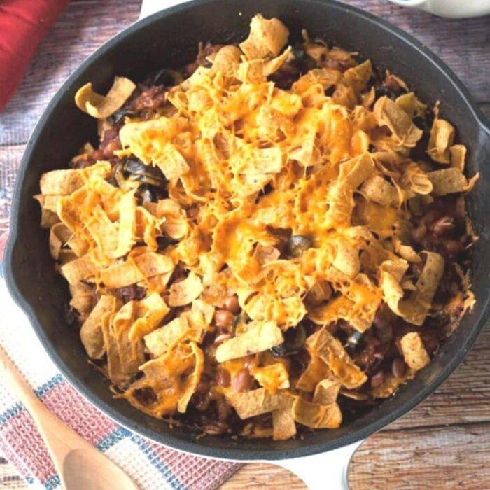 Chili corn chip casserole in a cast iron skillet