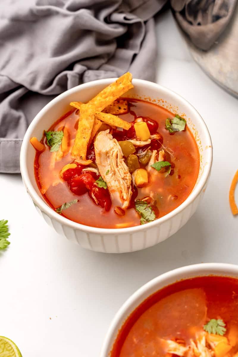 Bowl of copycat Chili's southwest chicken soup topped with tortilla strips and cilantro