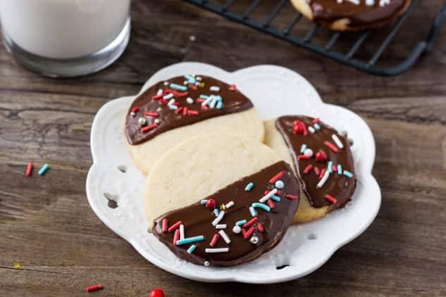 These easy chocolate dipped icebox cookies are the perfect make-ahead recipe for the holidays. Soft, buttery, dipped in chocolate & decorated with sprinkles.