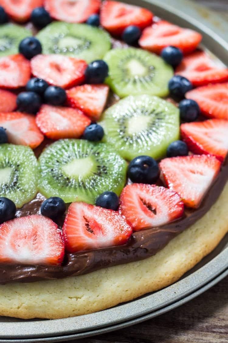 Chocolate fruit pizza is always a total crowd pleaser. With chewy sugar cookie, creamy chocolate cream cheese topping & fresh berries - you can't go wrong!