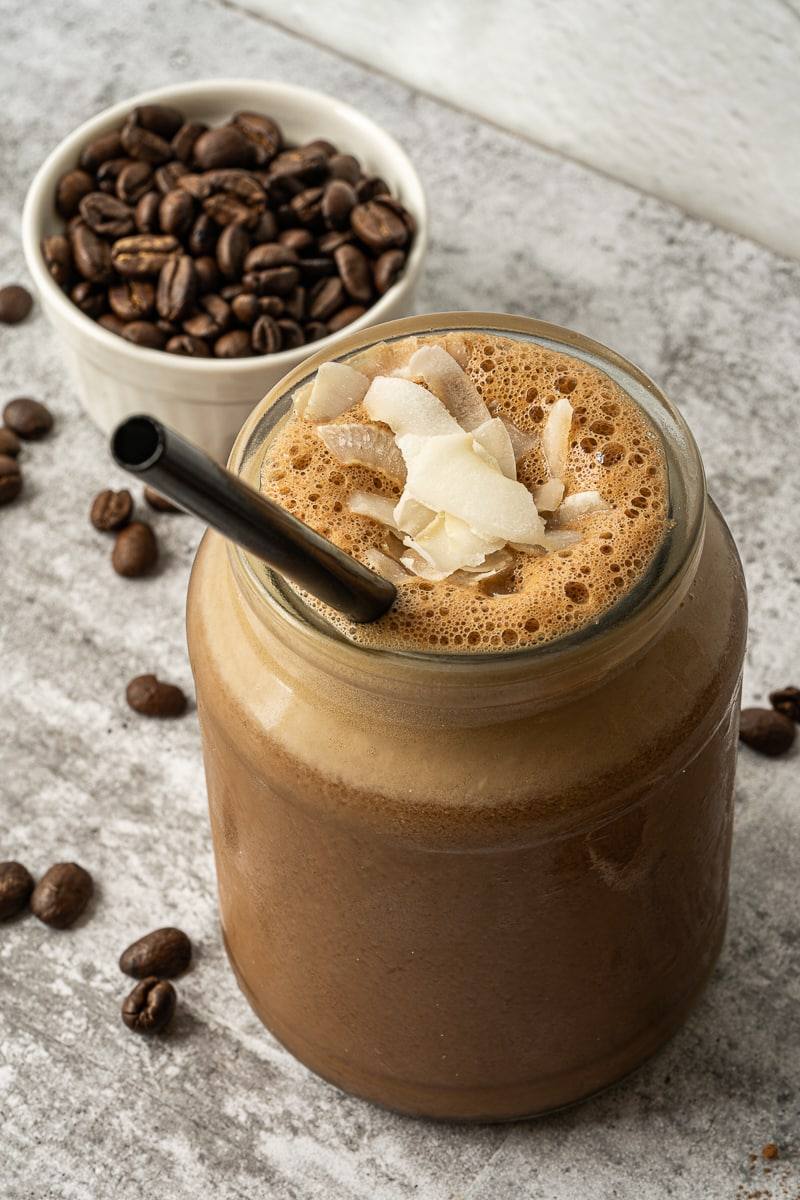 close up chocolate protein shake in jar with straw