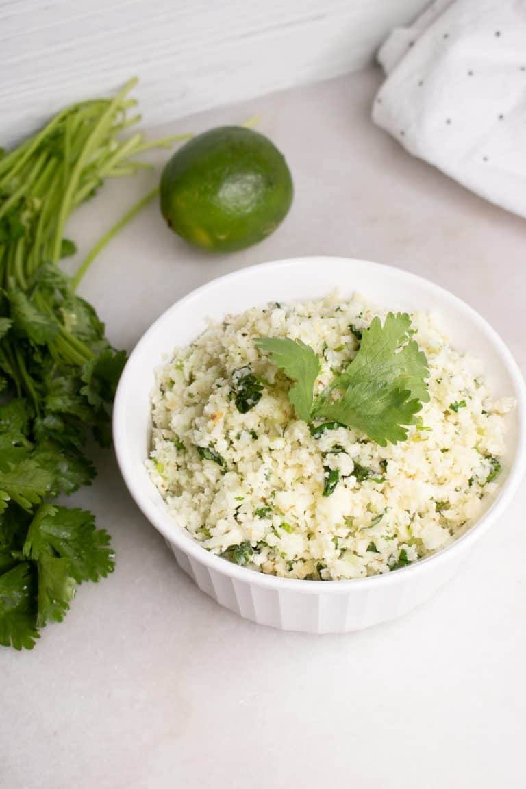 Birdseye view of Cilantro Lime Cauliflower Rice in white corning ware casserole with lime in background