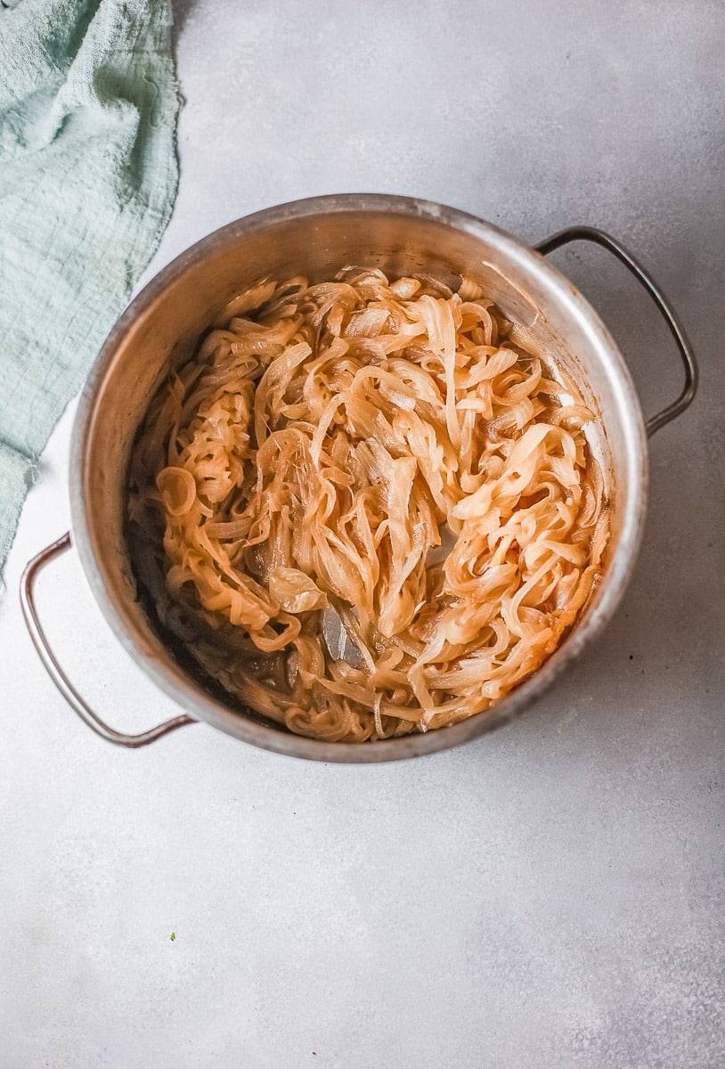Deep golden caramelized onions in a stainless steel pot