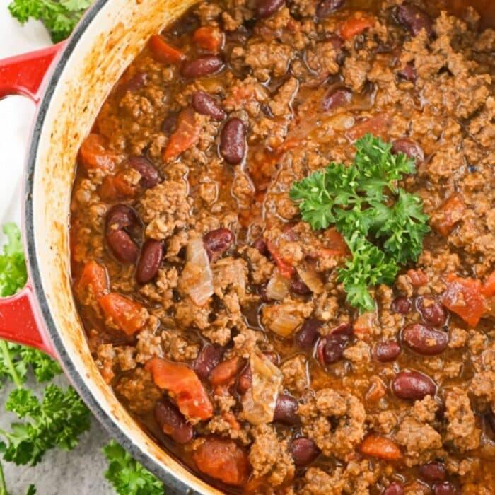 pot of copycat texas roadhouse chili with ground beef and kidney beans, garnished with parsley