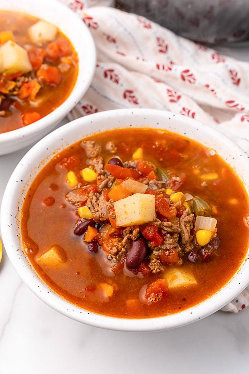 Close-up of a bowl of Crazy-Easy Cowboy Soup loaded with beef, beans, corn and diced potatoes