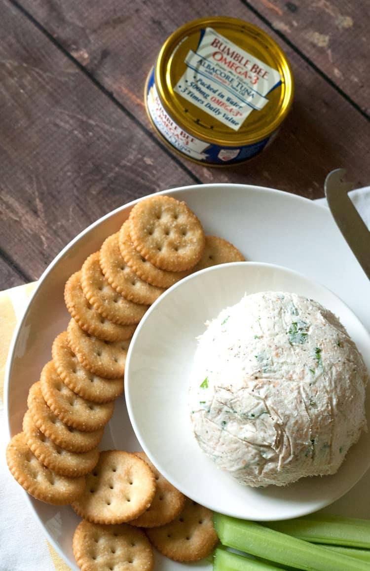 Tuna dip with cream cheese served with round crackers and celery, seen from above