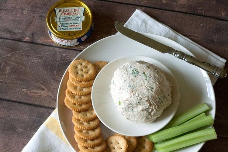 Overhead view of cream cheese tuna dip with crackers, celery and a spreading knife