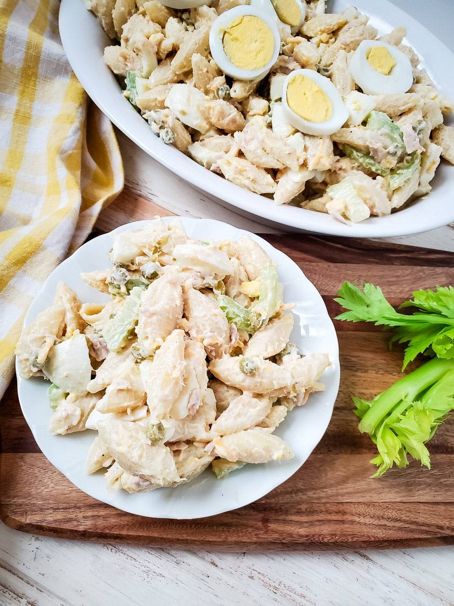plate of creamy tuna egg pasta salad next to serving dish