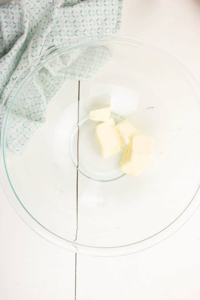 Butter for Dark chocolate brownies in clear glass bowl with blue and whit towel next to it