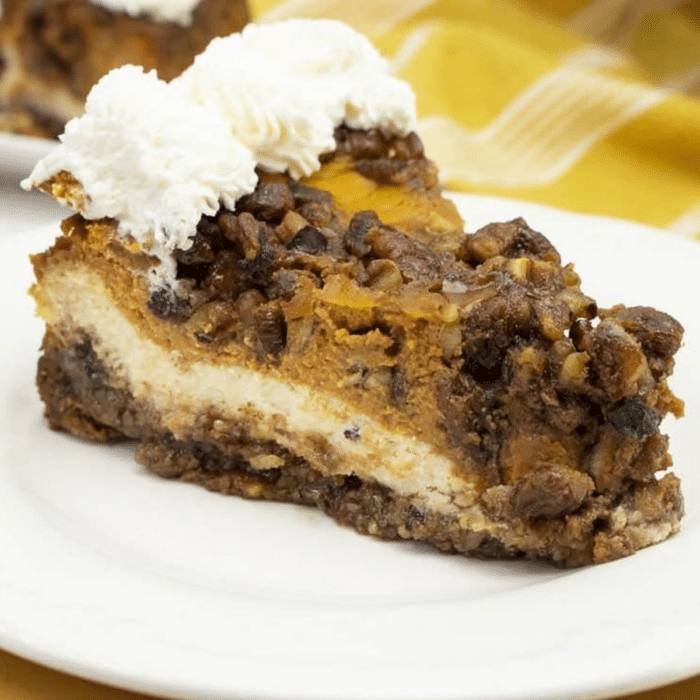 Slice of double layer pumpkin cheesecake with pecan streusel and whipped cream