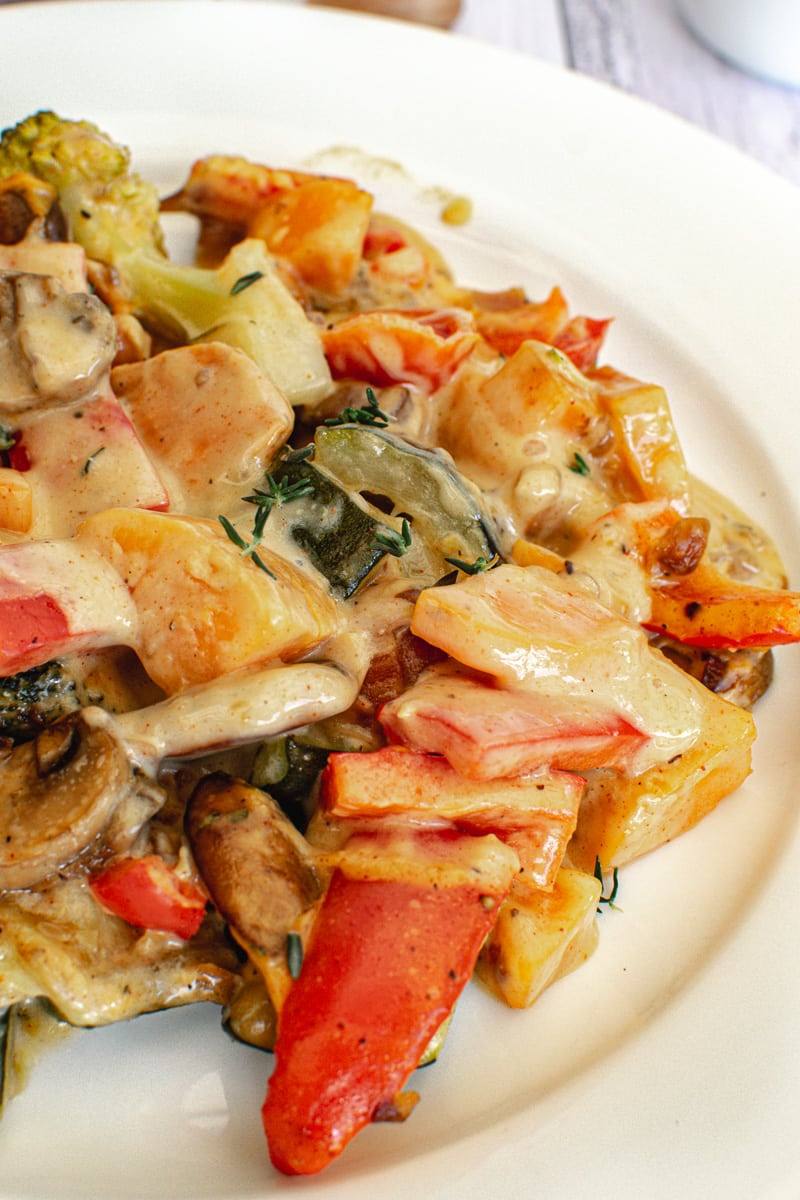 vegetables mixed with cheese sauce on plate side view