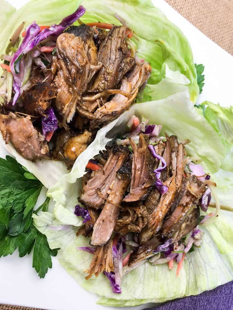 closeup of easy keto lettuce wraps containing pulled pork and red cabbage inside iceberg lettuce pieces