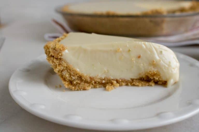 One slice of key lime pie served on a white plate.