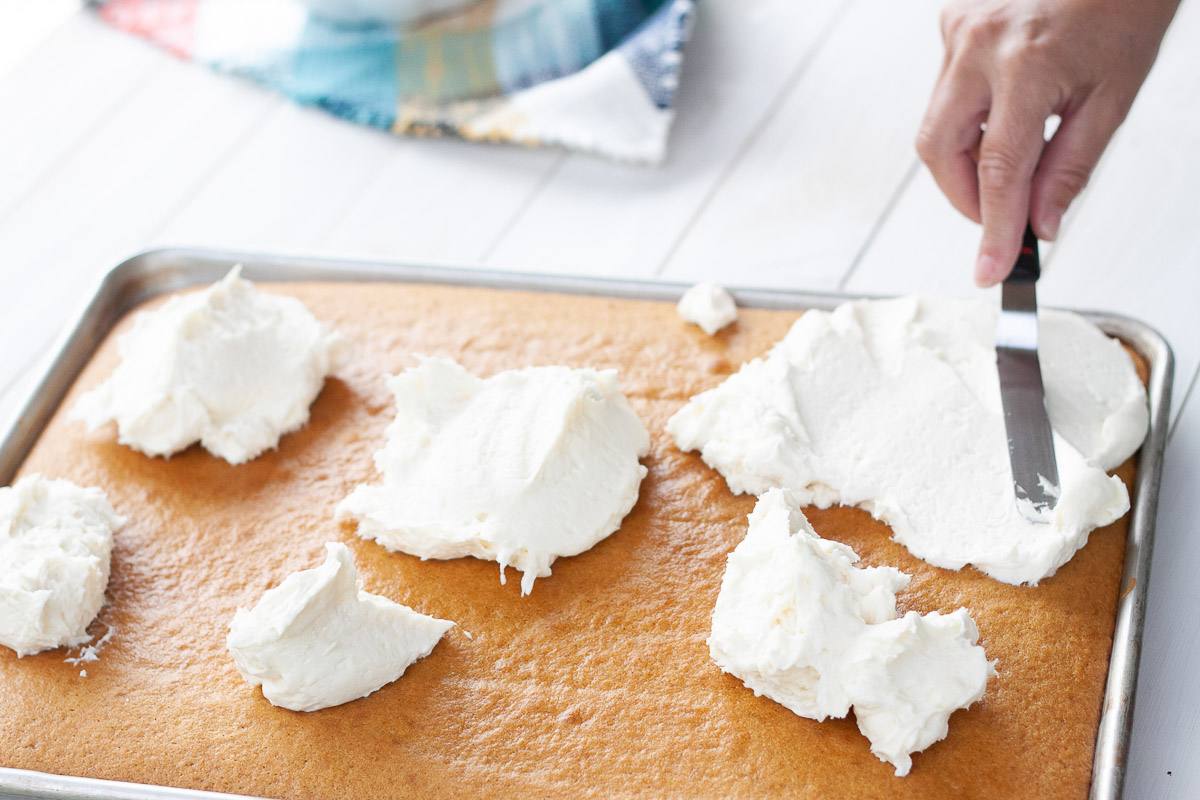 pumpkin bars getting frosted with cream cheese frosting