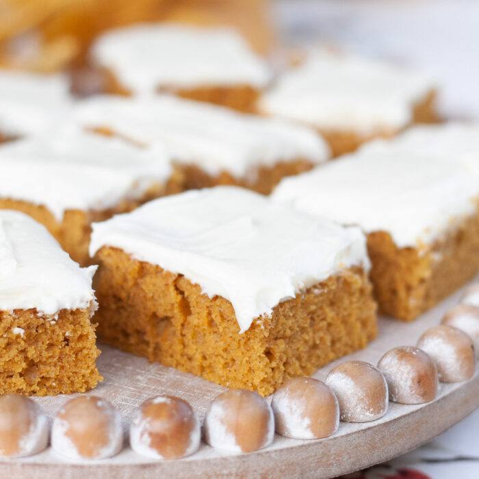 Close-up of a cream cheese frosted pumpkin bar showing its moist, tender crumb