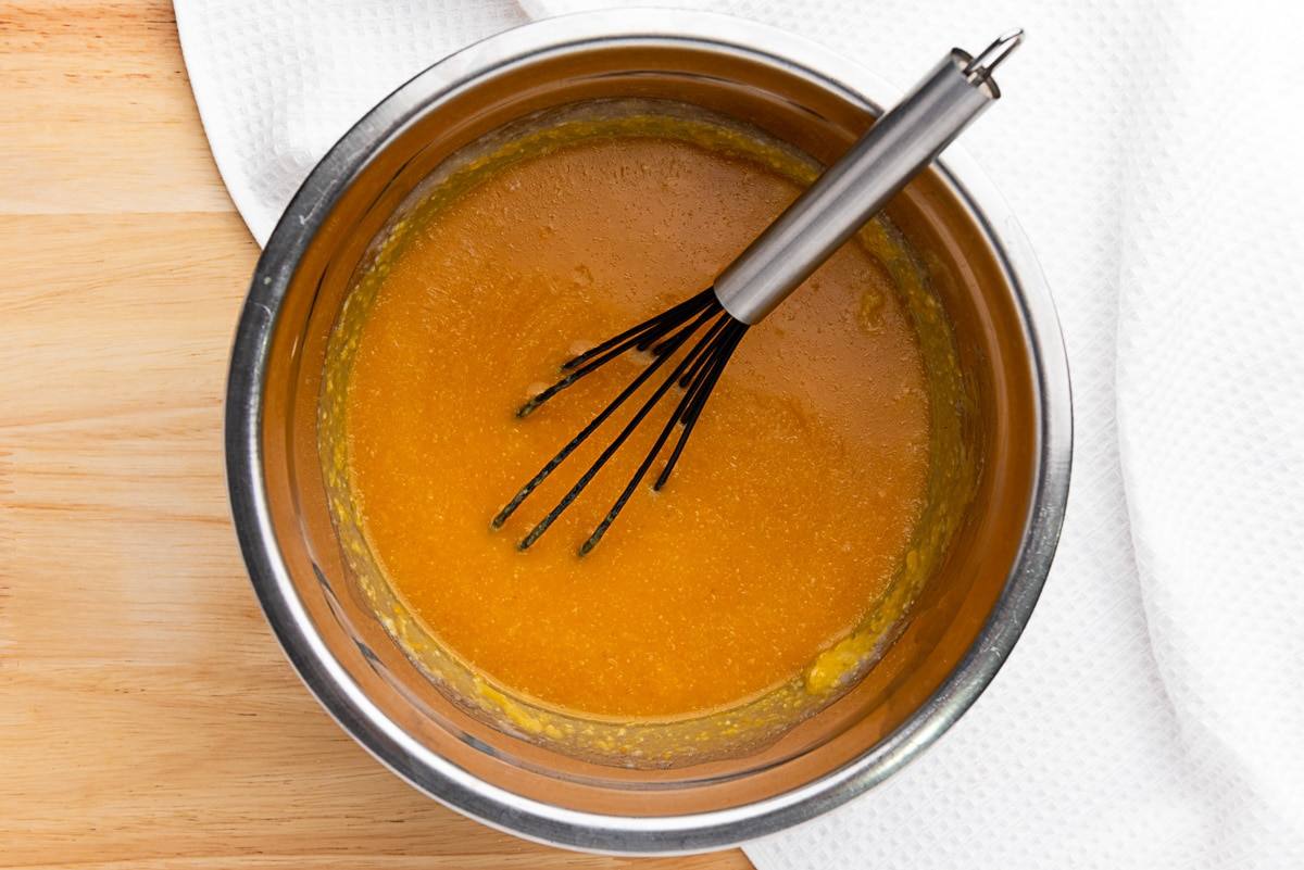 Pumpkin puree, milk, melted butter, and sugar whisked together in a metal mixing bowl