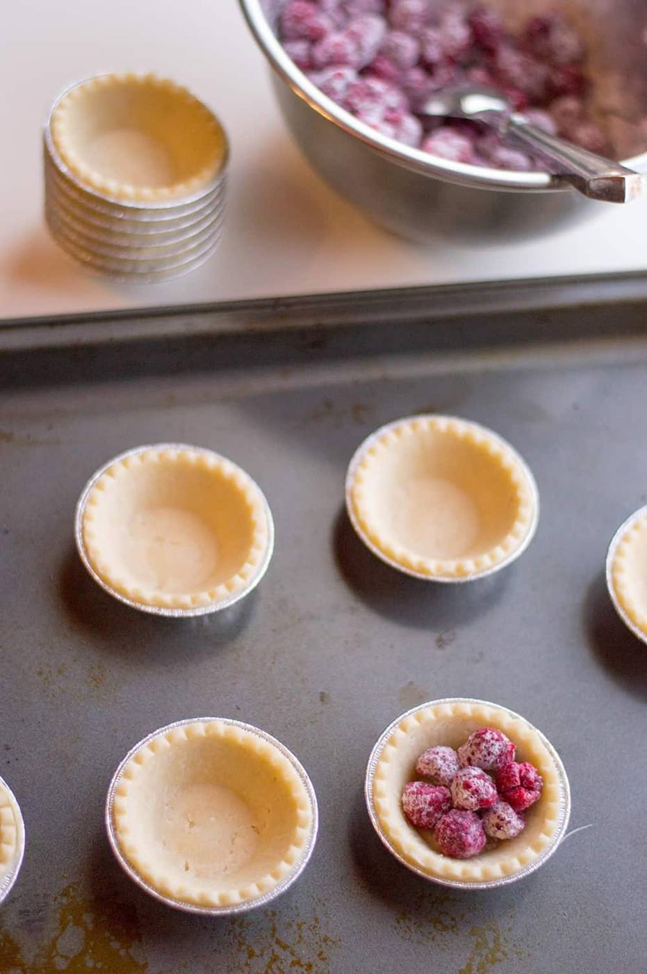 Raspberry mixture scooped into mini pie crusts