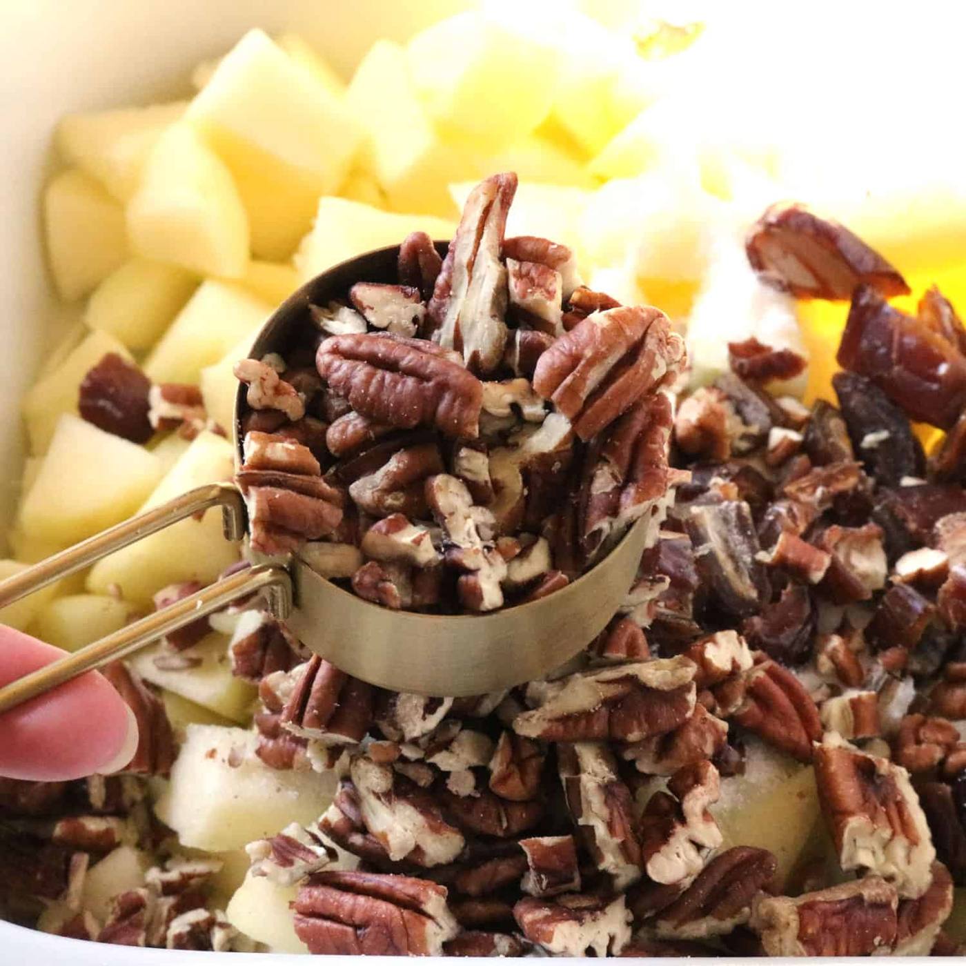 Chopped pecans added to the bread pudding ingredients in the slow cooker.