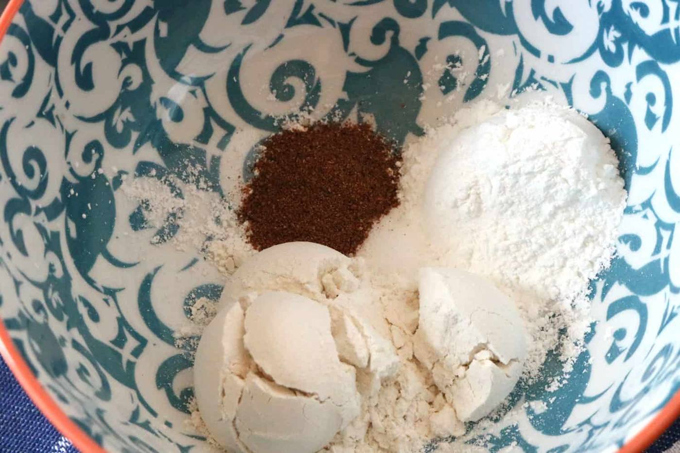 Flour, nutmeg, and baking powder mixed in separate bowl for bread pudding.