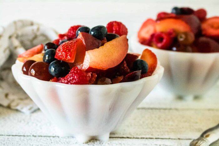servings of fruit salad with Honey Lime Dressing served in white scalloped bowls
