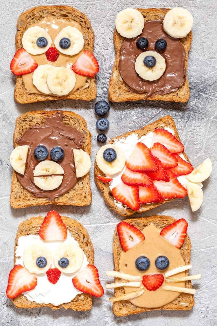 an assortment of fun decorated animal face toasts that look like monkeys, fish, bears, owls, cats, and birds.