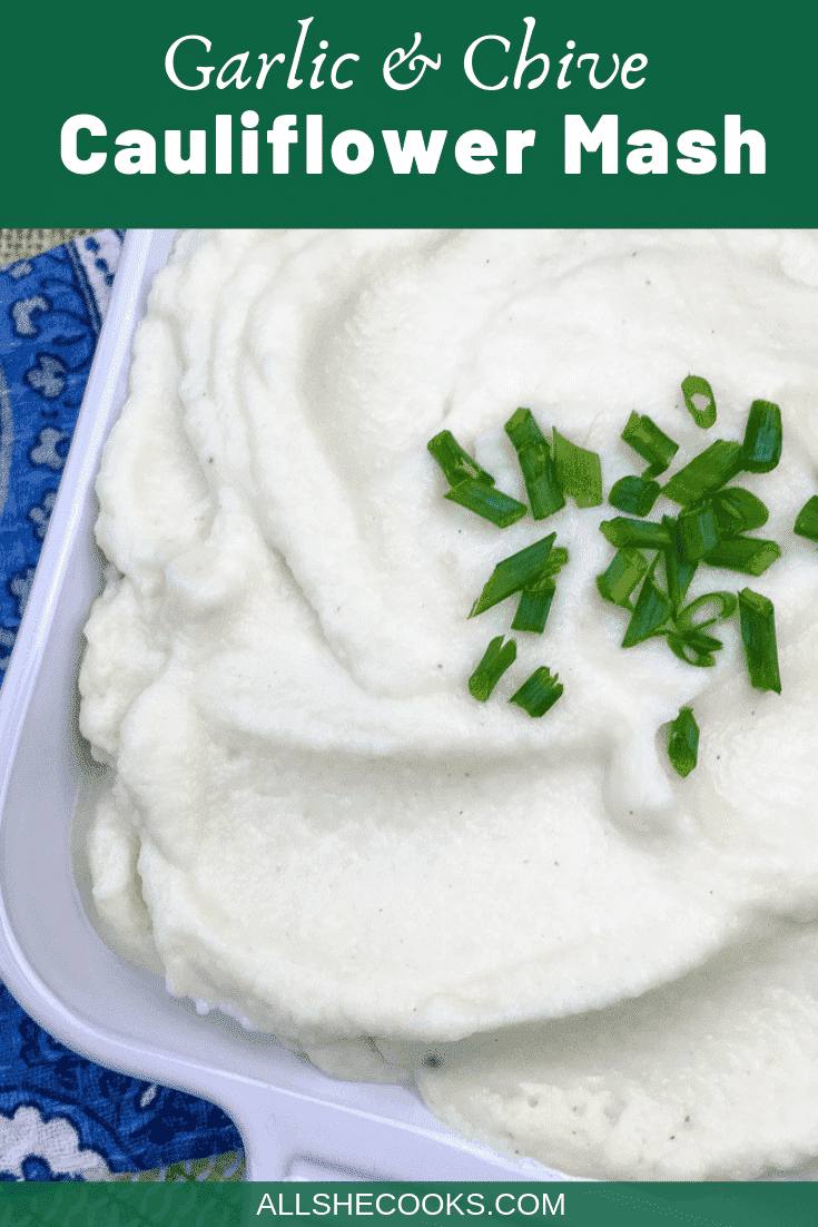 close up view of garlic and chive cauliflower mash in a white ceramic serving dish
