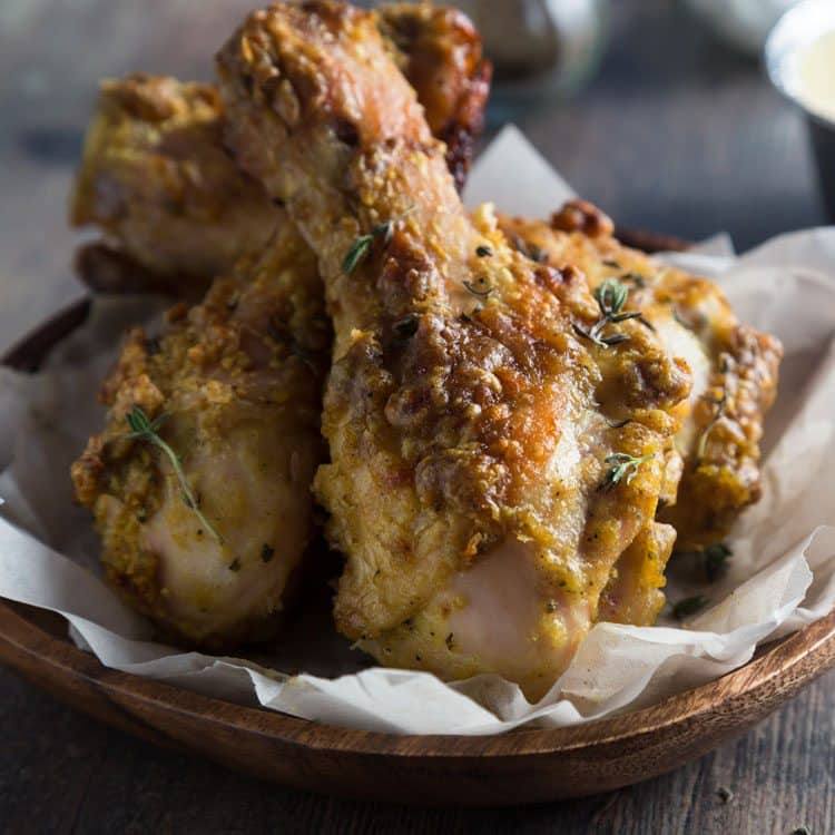 closeup of ginger fried chicken being served in a wooden bowl