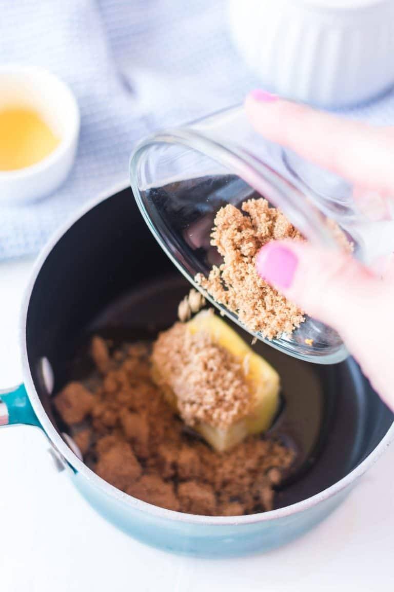 pouring brown sugar into a pan with butter and honey