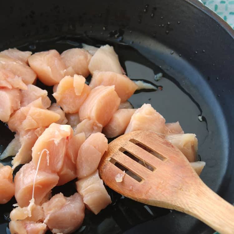 chicken being added to skillet for chicken fried rice recipe