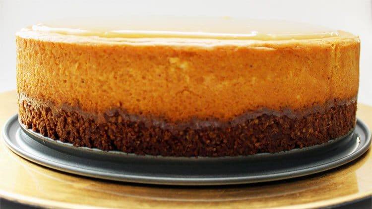 Side view of a gluten-free pumpkin maple cheesecake showing the thick pecan oat crust
